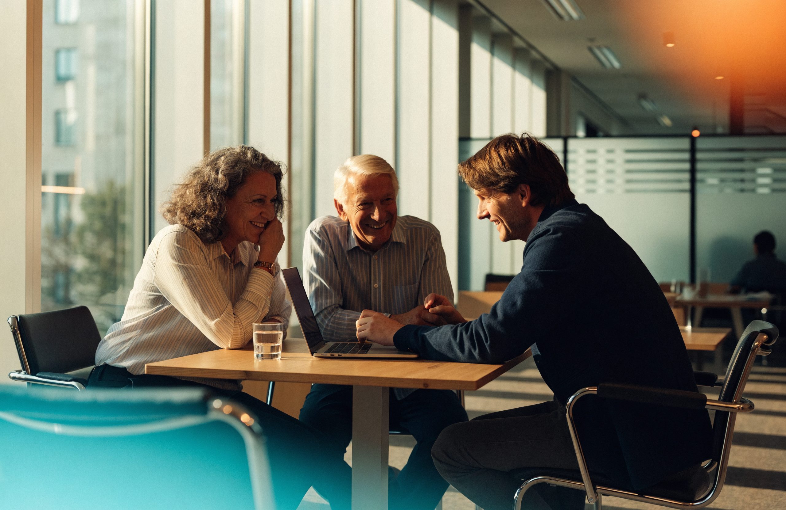 Twee ondernemers en hun adviseur van ATB aan tafel met een laptop