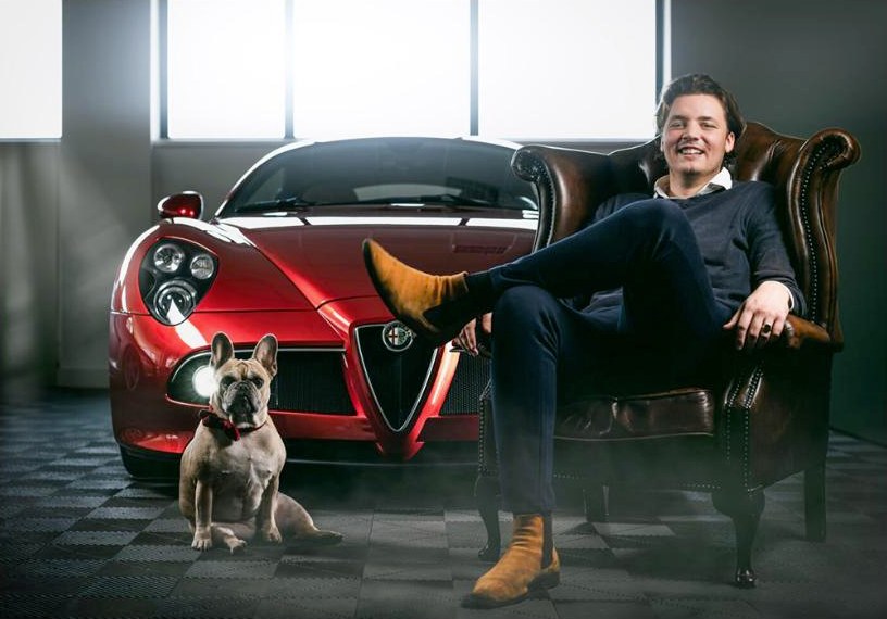 Dieter Tieleman in een chesterfield naast een rode Alfa Romeo 8C, met bulldog